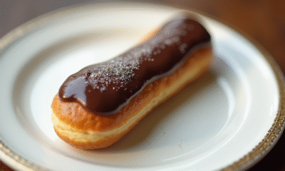 Éclair au chocolat sur une assiette blanche en gros plan