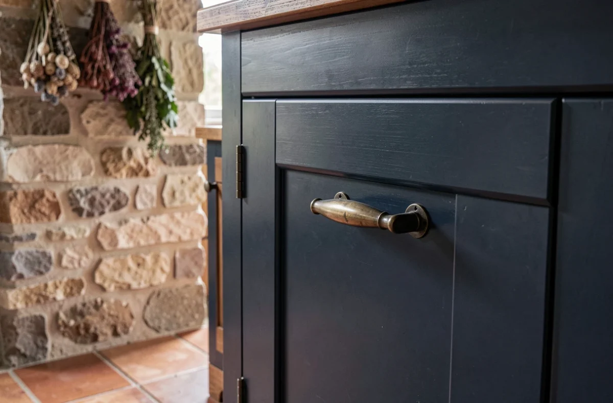 Porte de cuisine shaker bleu marine satiné avec quincaillerie bronze antique dans une cuisine de style campagne française