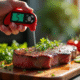 Thermomètre numérique dans un steak cuit sur une planche en bois